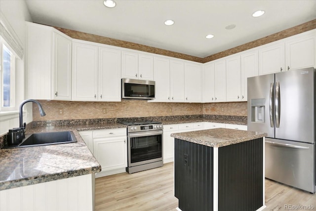 11575 Wilson Cir, Parker, CO 80134 - kitchen featuring appliances with stainless steel finishes, light wood-style flooring, a kitchen island, white cabinetry, and recessed lighting