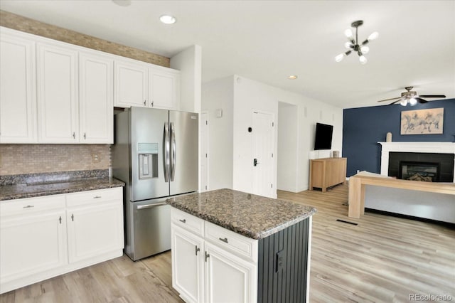 11575 Wilson Cir, Parker, CO 80134 - kitchen with stainless steel refrigerator with ice dispenser, a ceiling fan, decorative backsplash, light wood finished floors, and white cabinets