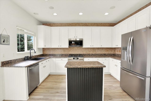11575 Wilson Cir, Parker, CO 80134 - kitchen featuring stainless steel appliances, a kitchen island, light wood finished floors, dark countertops, and white cabinets