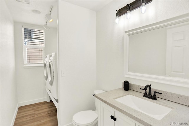 11575 Wilson Cir, Parker, CO 80134 - bathroom with independent washer and dryer, vanity, and wood finished floors