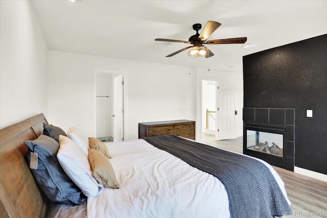 11575 Wilson Cir, Parker, CO 80134 - bedroom featuring wood finished floors, a multi sided fireplace, and a ceiling fan