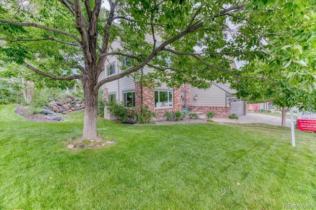 16642 W Archer Ave, Golden, CO 80401 - view of front of property with brick siding, driveway, a front yard, and a garage