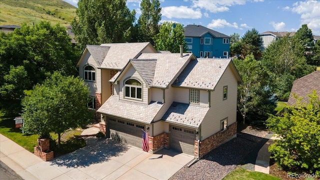 16642 W Archer Ave, Golden, CO 80401 - view of front of home featuring a high end roof, an attached garage, driveway, and stone siding