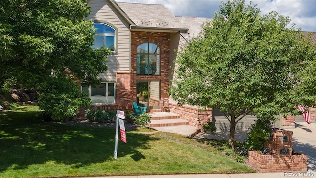 16642 W Archer Ave, Golden, CO 80401 - view of front of property with brick siding, a front lawn, and a garage