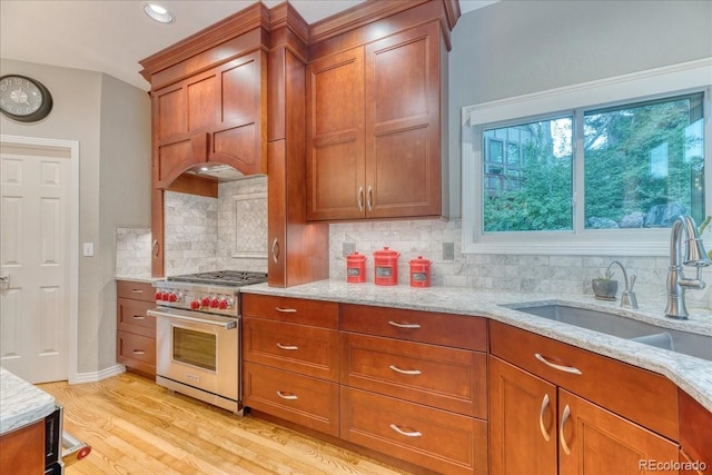 16642 W Archer Ave, Golden, CO 80401 - kitchen with premium range, brown cabinetry, light stone countertops, light wood-style flooring, and recessed lighting