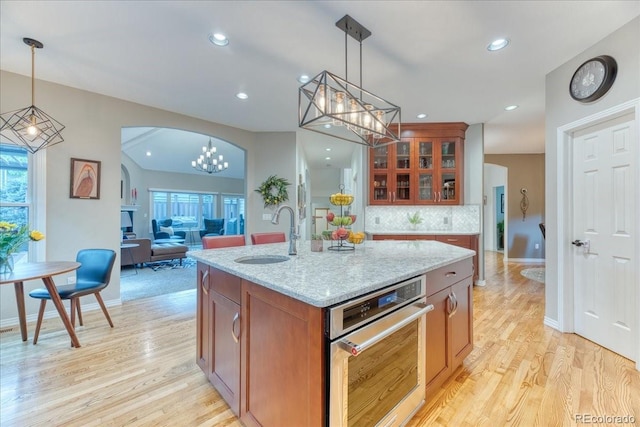 16642 W Archer Ave, Golden, CO 80401 - kitchen with a chandelier, brown cabinetry, light wood finished floors, backsplash, and recessed lighting