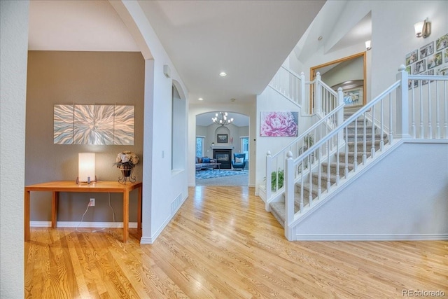 16642 W Archer Ave, Golden, CO 80401 - foyer entrance with arched walkways, wood finished floors, stairs, a chandelier, and recessed lighting