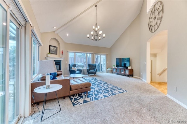 16642 W Archer Ave, Golden, CO 80401 - carpeted living area with high vaulted ceiling, arched walkways, plenty of natural light, a chandelier, and a glass covered fireplace