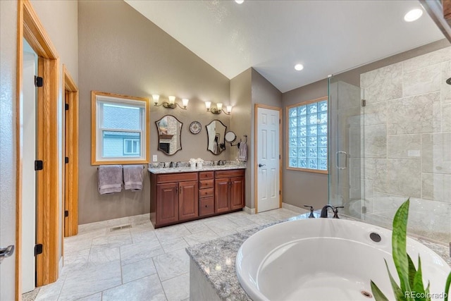 16642 W Archer Ave, Golden, CO 80401 - bathroom with vaulted ceiling, double vanity, a bath, a stall shower, and healthy amount of natural light