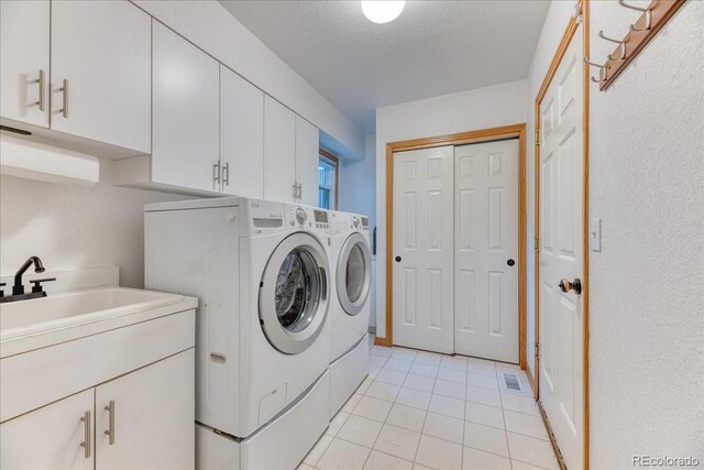 16642 W Archer Ave, Golden, CO 80401 - laundry room featuring washing machine and clothes dryer, light tile patterned flooring, and cabinet space
