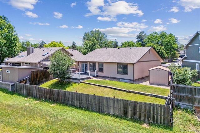 9015 W Tanforan Dr, Littleton, CO 80123 - back of property featuring a shed, a fenced backyard, and a wooden deck