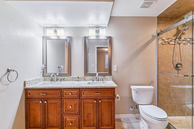9015 W Tanforan Dr, Littleton, CO 80123 - bathroom with double vanity, a stall shower, a textured wall, and a textured ceiling