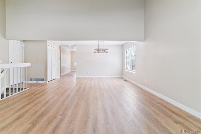 9015 W Tanforan Dr, Littleton, CO 80123 - empty room with light wood-type flooring and a chandelier