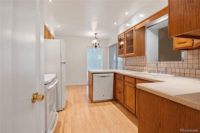 9115 W 5th Ave, Lakewood, CO 80226 - kitchen with white appliances, a sink, light wood finished floors, decorative backsplash, and brown cabinetry