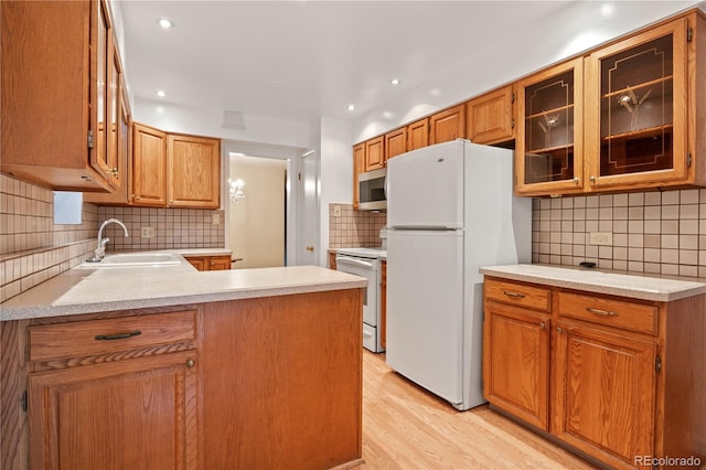9115 W 5th Ave, Lakewood, CO 80226 - kitchen featuring white appliances, a sink, decorative backsplash, light wood-style flooring, and light countertops