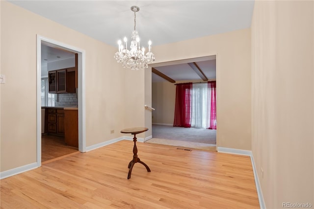 9115 W 5th Ave, Lakewood, CO 80226 - unfurnished dining area featuring light wood-style floors, a chandelier, baseboards, and beam ceiling