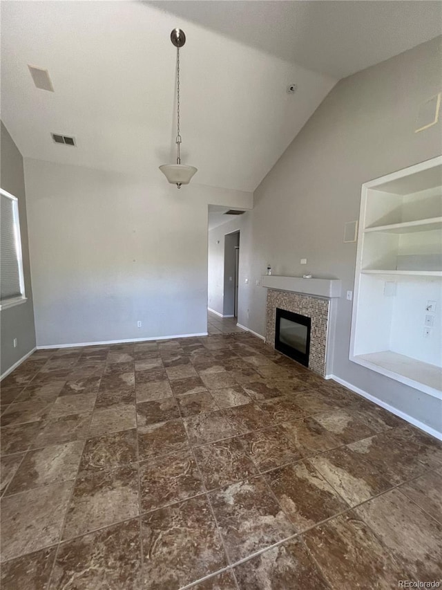 unfurnished living room featuring a tiled fireplace and vaulted ceiling