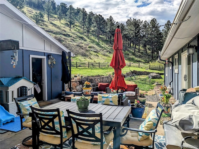 5384 Olde Stage Rd, Boulder, CO 80302 - view of patio with fence, a wooded view, and outdoor dining area