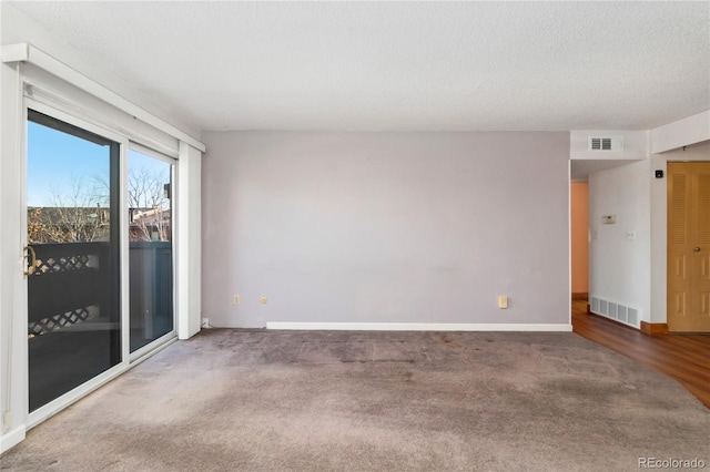 carpeted empty room with baseboards, visible vents, and a textured ceiling