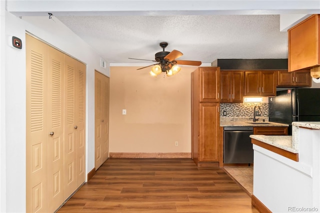 kitchen with a ceiling fan, light wood-style flooring, freestanding refrigerator, a sink, and stainless steel dishwasher