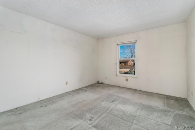 spare room featuring a textured ceiling and carpet