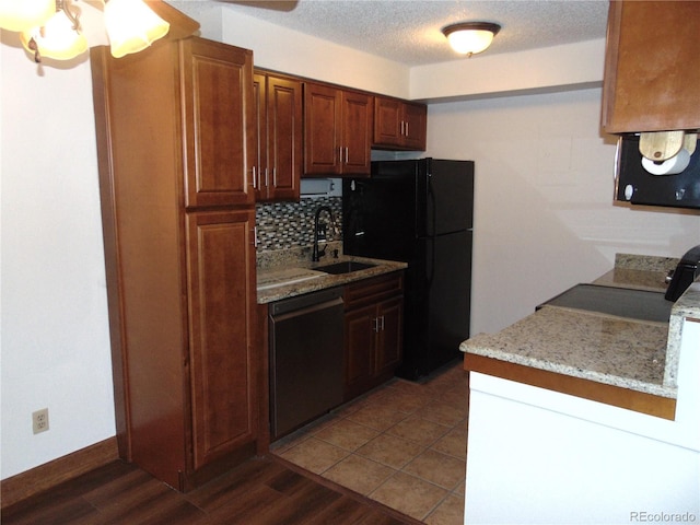 kitchen with dark wood-style floors, a sink, freestanding refrigerator, backsplash, and dishwashing machine