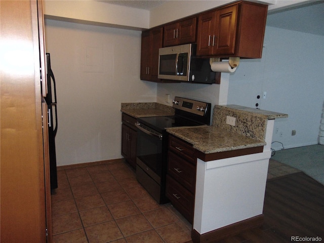kitchen with baseboards, appliances with stainless steel finishes, and light stone countertops