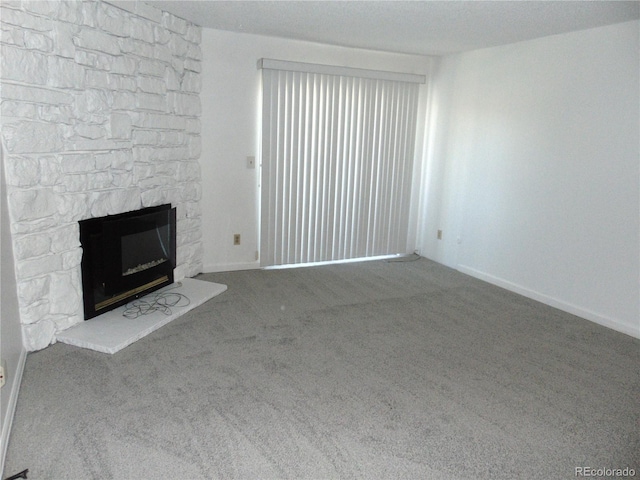 unfurnished living room with a fireplace, carpet floors, and baseboards