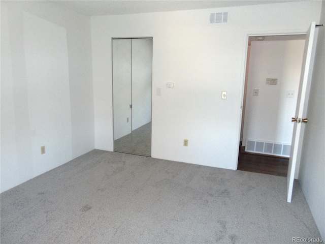 unfurnished bedroom with a closet, carpet, and visible vents