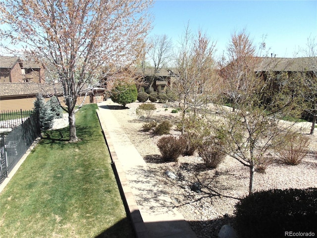 view of community with a yard and fence