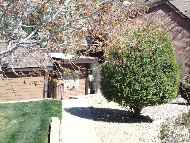 view of side of home with brick siding and a yard