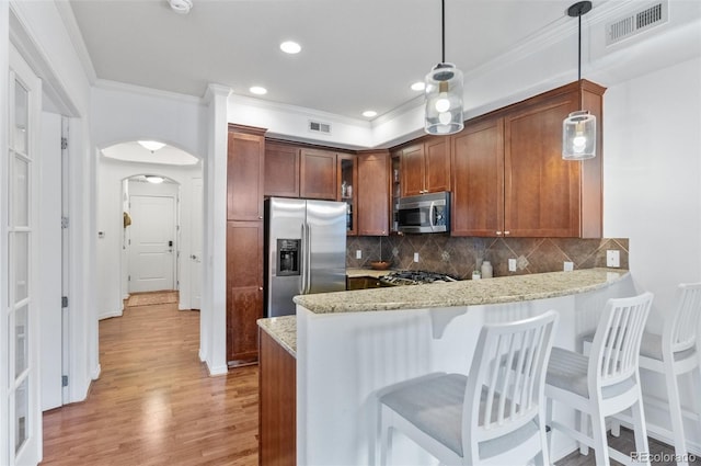 1776 Race St Unit 109, Denver, CO 80206 - kitchen with appliances with stainless steel finishes, crown molding, a peninsula, light wood finished floors, and tasteful backsplash