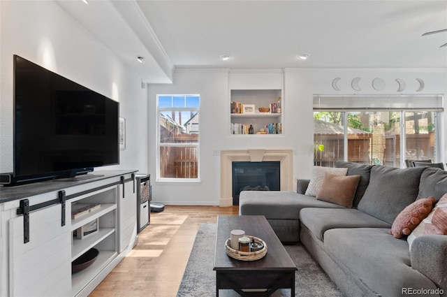 1776 Race St Unit 109, Denver, CO 80206 - living area featuring ornamental molding, light wood finished floors, a glass covered fireplace, and ceiling fan