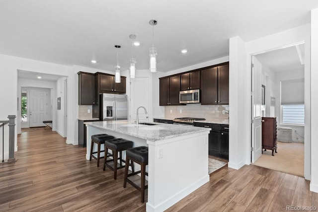 15802 Xanthia Way, Thornton, CO 80602 - kitchen featuring stainless steel appliances, wood finished floors, dark brown cabinets, backsplash, and recessed lighting