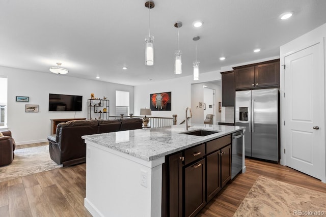 15802 Xanthia Way, Thornton, CO 80602 - kitchen featuring stainless steel appliances, open floor plan, wood finished floors, dark brown cabinets, and recessed lighting