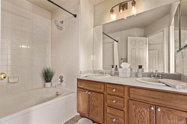 full bathroom featuring double vanity, shower / bathing tub combination, and a sink