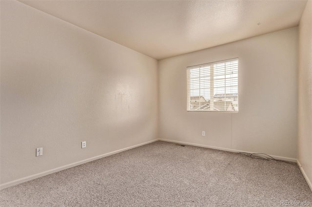 unfurnished room featuring baseboards and carpet flooring