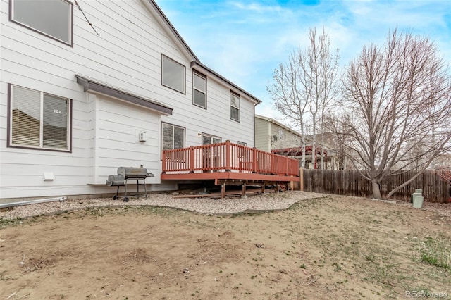 back of property with fence and a deck