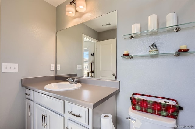 half bathroom featuring vanity and toilet