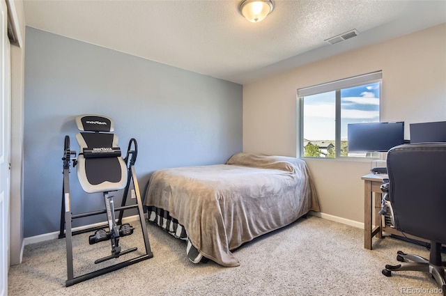bedroom featuring carpet, baseboards, a desk, and a textured ceiling
