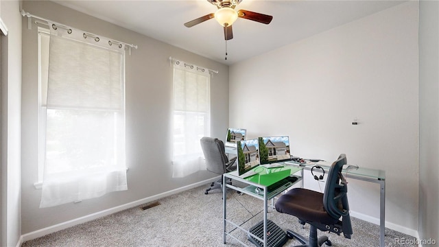 carpeted home office with ceiling fan, visible vents, and baseboards