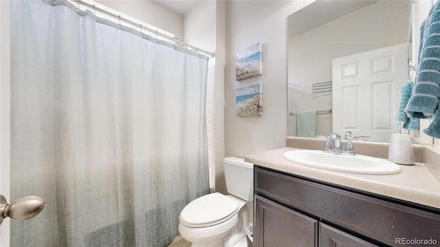 bathroom featuring toilet, a shower with shower curtain, and vanity