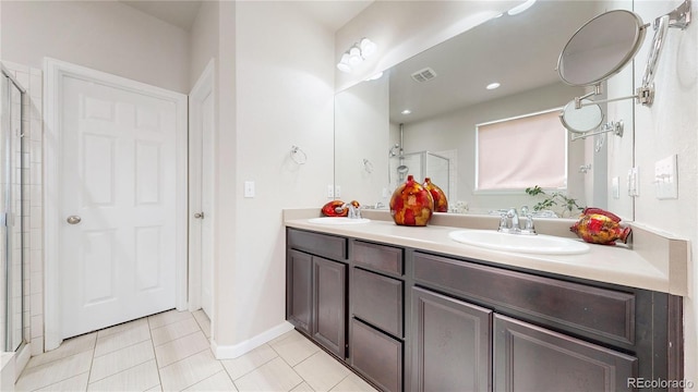 bathroom featuring tile patterned flooring, visible vents, a sink, and double vanity