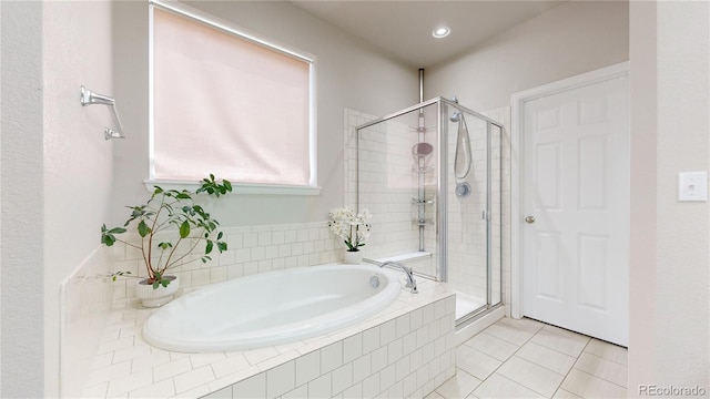 full bathroom with a stall shower, a bath, and tile patterned floors