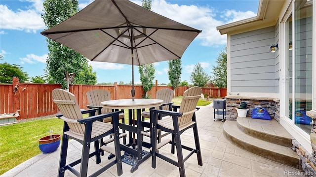 view of patio with outdoor dining area and a fenced backyard