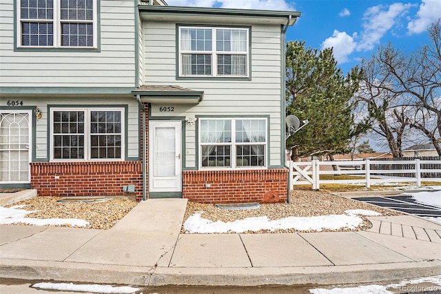 townhome / multi-family property featuring fence and brick siding