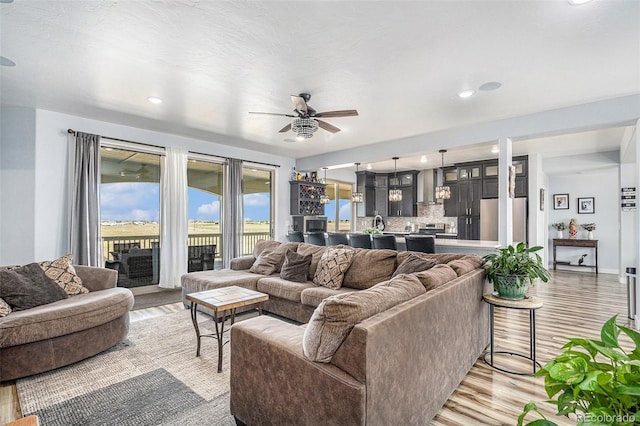 living room with recessed lighting, ceiling fan, and light wood finished floors