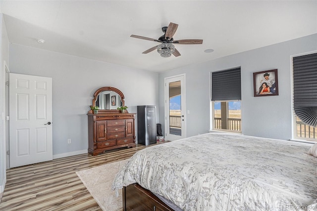 bedroom with a ceiling fan, baseboards, and wood finished floors