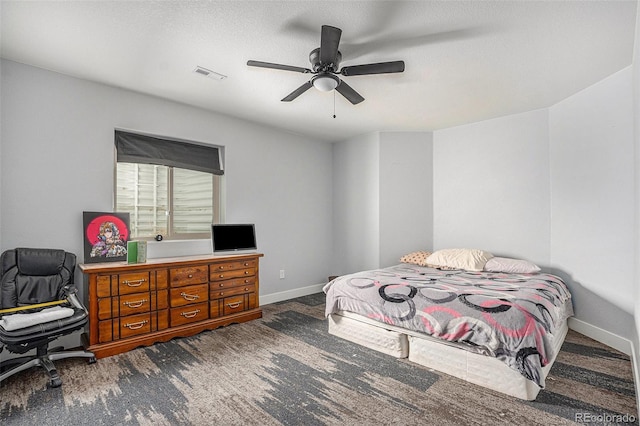 carpeted bedroom with baseboards, visible vents, and a ceiling fan