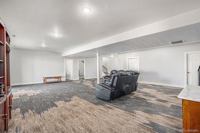 carpeted living room featuring visible vents, a textured ceiling, and baseboards